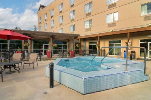 a swimming pool with a large blue umbrella at Best Western Plus Revelstoke in Revelstoke