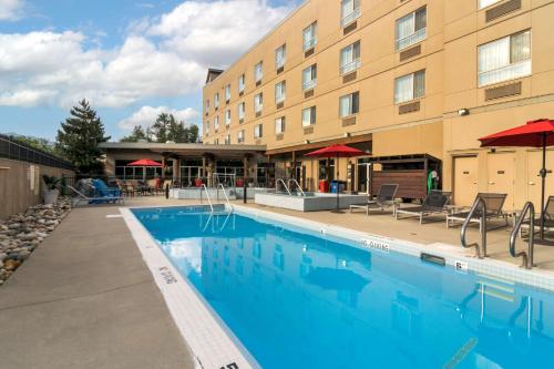 a pool at a hotel with chairs and umbrellas at Best Western Plus Revelstoke in Revelstoke