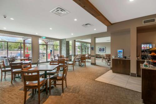 un comedor con mesas, sillas y ventanas en Best Western Plus Revelstoke, en Revelstoke