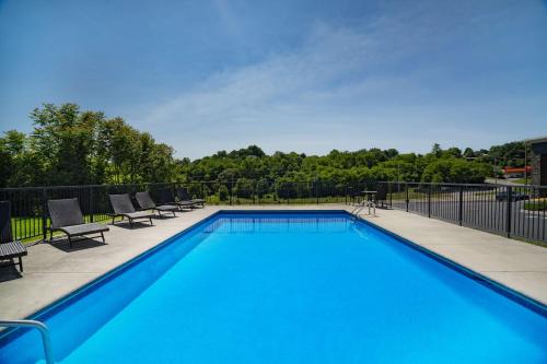 une grande piscine avec des chaises et une clôture dans l'établissement La Quinta by Wyndham Sevierville / Kodak, à Sevierville