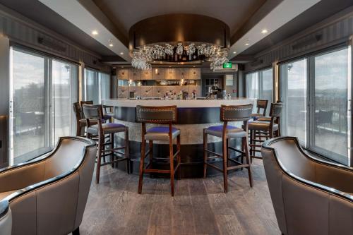 a bar in a restaurant with chairs and windows at Best Western Plus Edmundston in Edmundston