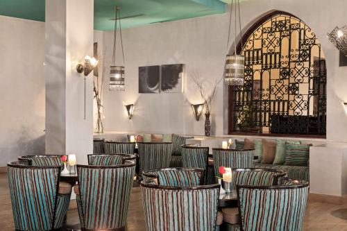 a restaurant with striped chairs and a table with candles at Radisson Blu Resort El Quseir in Quseir