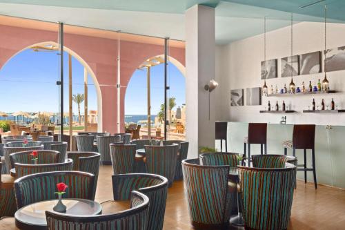 a restaurant with chairs and a bar with a view at Radisson Blu Resort El Quseir in Quseir