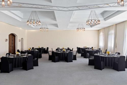 a room with black tables and chairs and chandeliers at Radisson Blu Resort El Quseir in Quseir