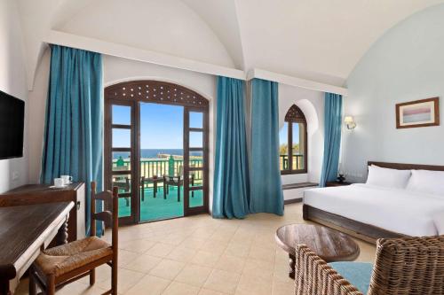 a bedroom with a bed and a balcony at Radisson Blu Resort El Quseir in Quseir