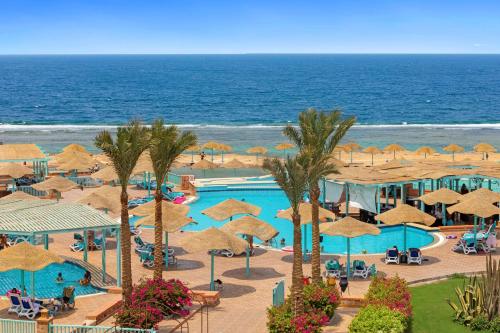 a view of a pool with umbrellas and the ocean at Radisson Blu Resort El Quseir in Quseir