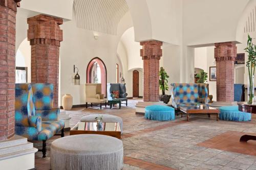 a lobby with blue chairs and a table at Radisson Blu Resort El Quseir in Quseir