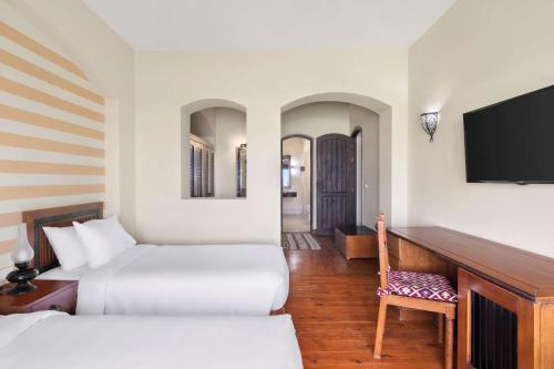 a hotel room with two beds and a flat screen tv at Radisson Blu Resort El Quseir in Quseir
