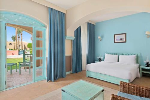a hotel room with a bed and a patio at Radisson Blu Resort El Quseir in Quseir