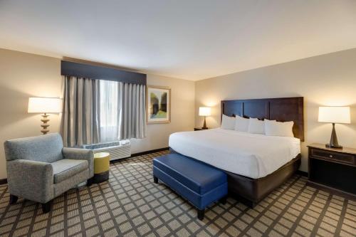 um quarto de hotel com uma cama e uma cadeira em Best Western North Bryant Inn em San Angelo