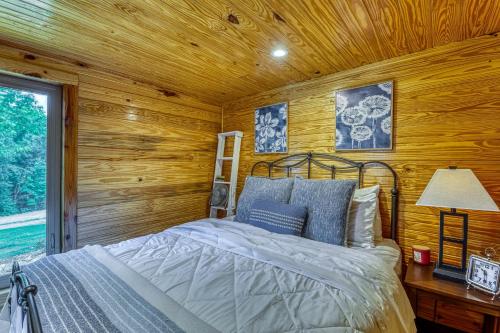 ein Schlafzimmer mit einem Bett in einer Blockhütte in der Unterkunft The Gemini-a dreamy, waterfront tiny cabin in Rogersville