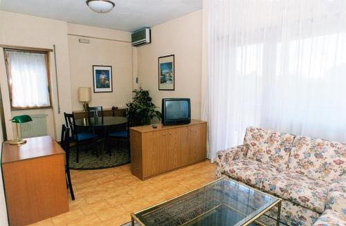 sala de estar con sofá y TV en Eur Nir Residence, en Roma