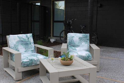 a pair of chairs and a table with a plant at māra in Mapua