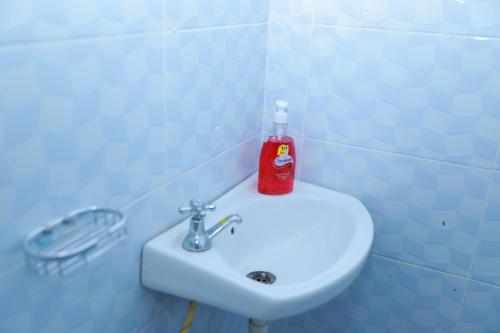 a red bottle of soap sitting on top of a white sink at Executive studio in Ruiru in Ruiru