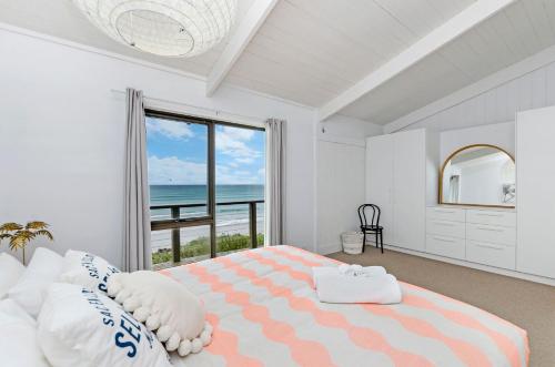 a bedroom with a bed with a view of the ocean at Two Two Two in Port Fairy