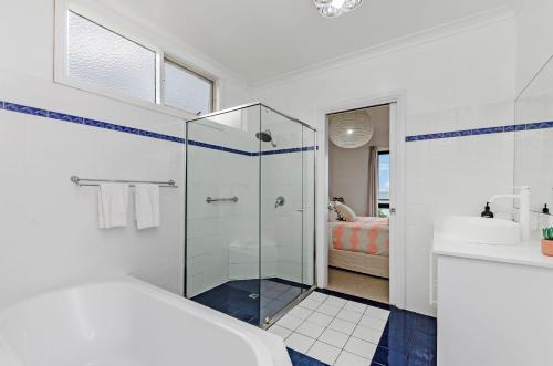 a white bathroom with a shower and a sink at Two Two Two in Port Fairy