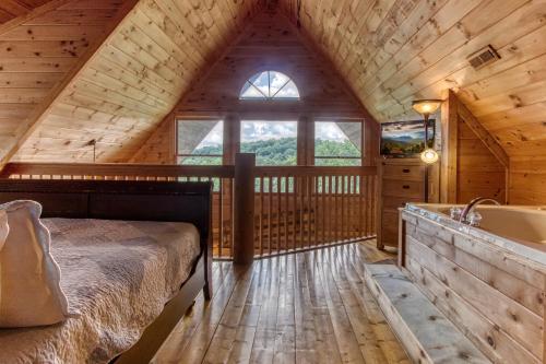 a bedroom in a log cabin with a bed and a tub at Alone At Last- Hot Tub, Cozy Cabin Retreat in the Smokies in Pigeon Forge