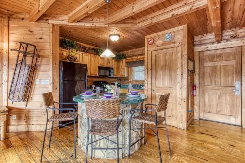 a kitchen with a table and chairs in a cabin at Alone At Last- Hot Tub, Cozy Cabin Retreat in the Smokies in Pigeon Forge
