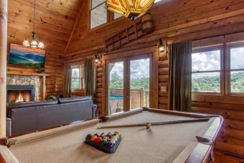 a pool table in a room with a fireplace at Alone At Last- Hot Tub, Cozy Cabin Retreat in the Smokies in Pigeon Forge
