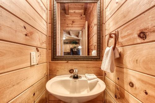 a bathroom with a sink and a mirror at Alone At Last- Hot Tub, Cozy Cabin Retreat in the Smokies in Pigeon Forge