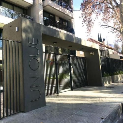 una puerta frente a un edificio con una valla en Departamento en complejo residencial en Mendoza