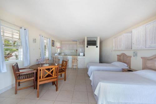 Zimmer mit 2 Betten, einem Tisch und einer Küche in der Unterkunft Ocean Bliss Apartments in Christchurch