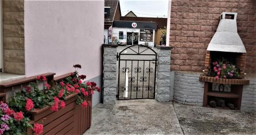 una entrada a un edificio con una puerta negra y flores en Location-Meublé, en Issenheim