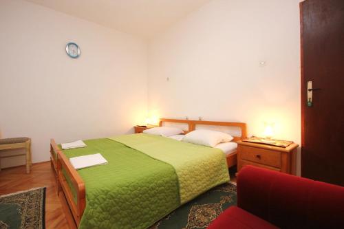 Apartment Orebic 4546c في أوربيك: غرفة نوم بسرير اخضر وكرسي