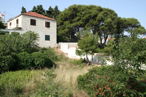 a house on top of a hill with trees at Apartments and rooms by the sea Jelsa, Hvar - 4602 in Jelsa