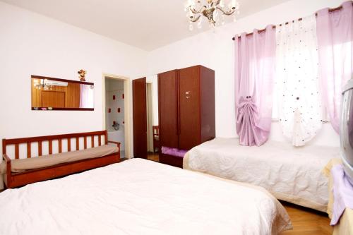 a bedroom with two beds and a chandelier at Apartment Jelsa 4602c in Jelsa