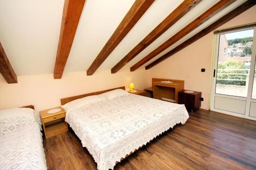 1 dormitorio con cama y ventana grande en Apartments and rooms by the sea Jelsa, Hvar - 4602 en Jelsa