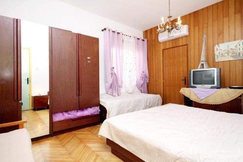 1 dormitorio con 2 camas y TV. en Apartments and rooms by the sea Jelsa, Hvar - 4602 en Jelsa