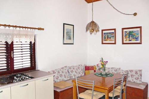 a kitchen with a table and a dining room with a stove at Apartments by the sea Brna, Korcula - 5902 in Smokvica