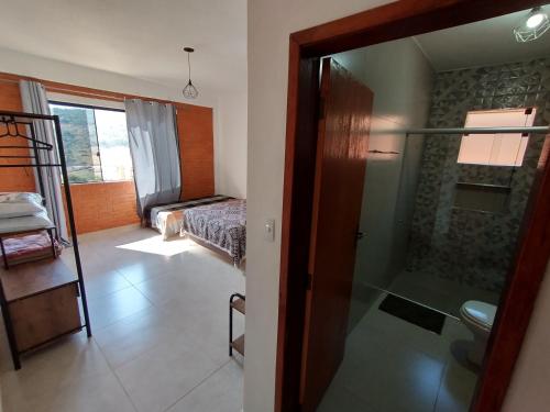 a room with a glass door leading to a bedroom at Casa Amantes da Serra Ibitipoca - Sua melhor opção! in Conceição da Ibitipoca
