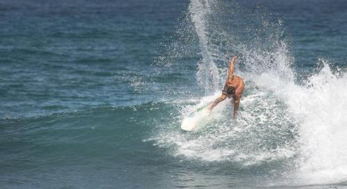 a man riding a wave on a surfboard in the ocean at Hosteria Farallon Dillon in Ballenita