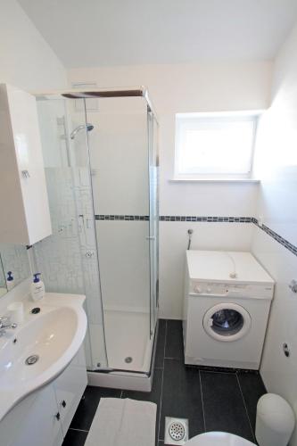a bathroom with a shower and a washing machine at Apartments by the sea Vinjerac, Zadar - 5811 in Vinjerac