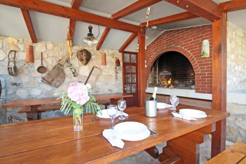 een eetkamer met een tafel en een stenen open haard bij Apartments by the sea Vinjerac, Zadar - 5824 in Vinjerac