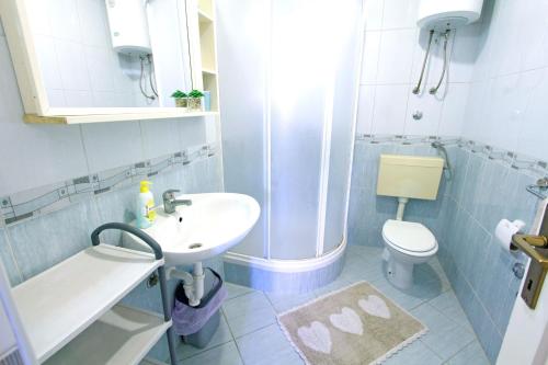 La salle de bains est pourvue d'un lavabo et de toilettes. dans l'établissement Apartments with a parking space Nin, Zadar - 5797, à Nin