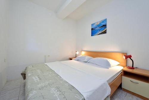 um quarto com uma grande cama branca e um candeeiro em Family friendly apartments with a swimming pool Drage, Biograd - 5904 em Drage