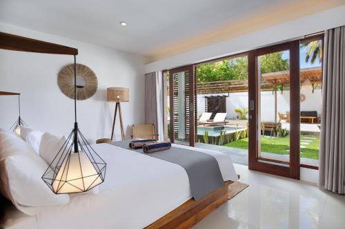 a bedroom with a bed and a view of a patio at Villa Sakura. Luxury 3 Bedroom Villa. in Selong Belanak