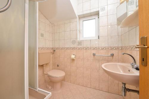 uma casa de banho com um WC e um lavatório em Family friendly apartments with a swimming pool Drage, Biograd - 5904 em Drage