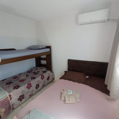 a bedroom with a bed and a bunk bed with a pillow at Apto Agua Marinha in Campos dos Goytacazes