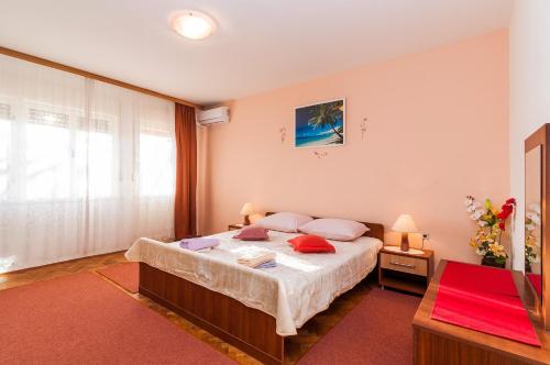 um quarto com uma cama grande e um tapete vermelho em Apartments for families with children Privlaka, Zadar - 5747 em Privlaka