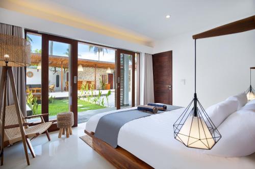 a bedroom with a large bed and a patio at Villa Sakura. Luxury 3 Bedroom Villa. in Selong Belanak