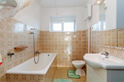 uma casa de banho com uma banheira, um WC e um lavatório. em Apartments for families with children Privlaka, Zadar - 5747 em Privlaka
