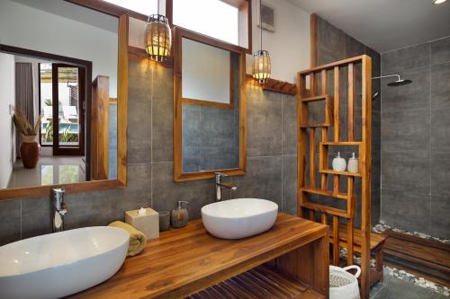 a bathroom with a large white sink and a mirror at Villa Sakura. Luxury 3 Bedroom Villa. in Selong Belanak