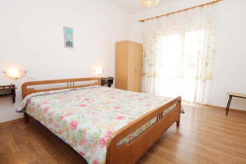 1 dormitorio con 1 cama con colcha de flores en Apartments by the sea Vrsi - Mulo, Zadar - 5790, en Vrsi