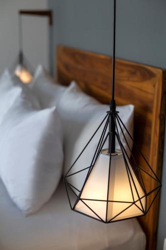 a black and white pendant light hanging over a bed at Villa Sakura. Luxury 3 Bedroom Villa. in Selong Belanak