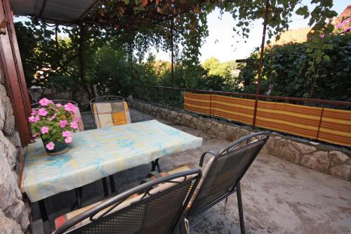 una mesa y sillas en un patio con flores en Apartments with a parking space Jelsa, Hvar - 5728, en Jelsa