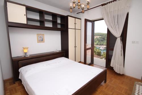 um quarto com uma cama grande e uma varanda em Apartments with a parking space Jelsa, Hvar - 5728 em Jelsa